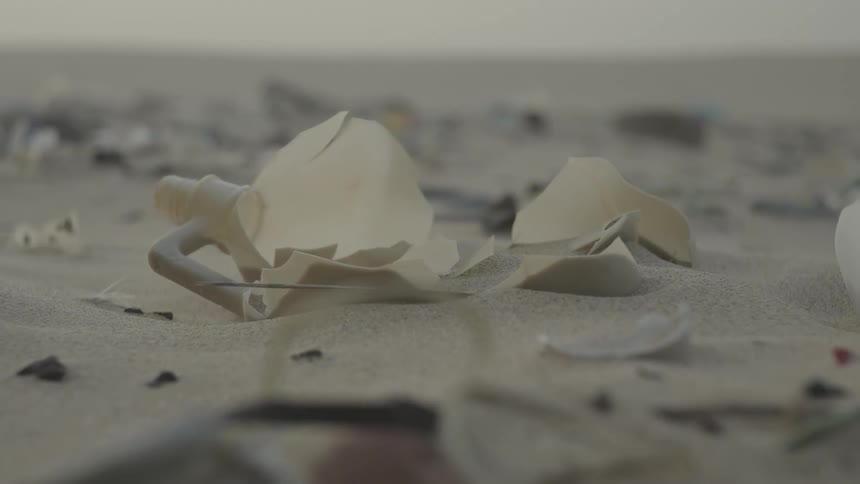 Shards of a plastic jug scattered over sand