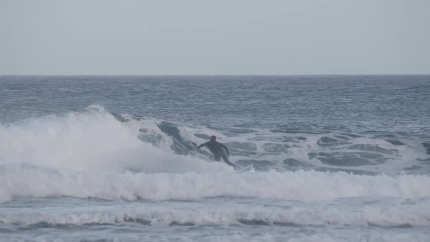 Man surfing strong waves and doing radical maneuvers