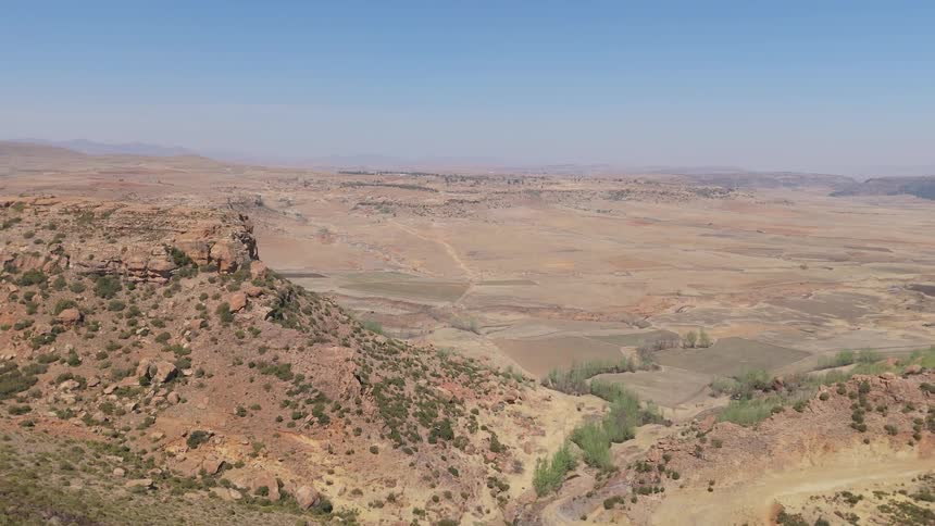 Aerial of mountains in a desert plain on a sunny day