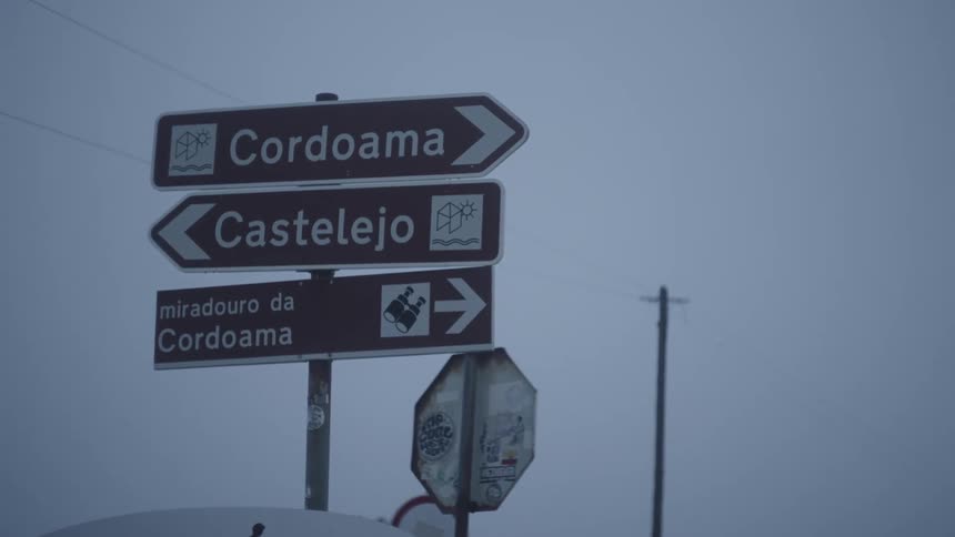 Several traffic signs in portuguese point in different directions