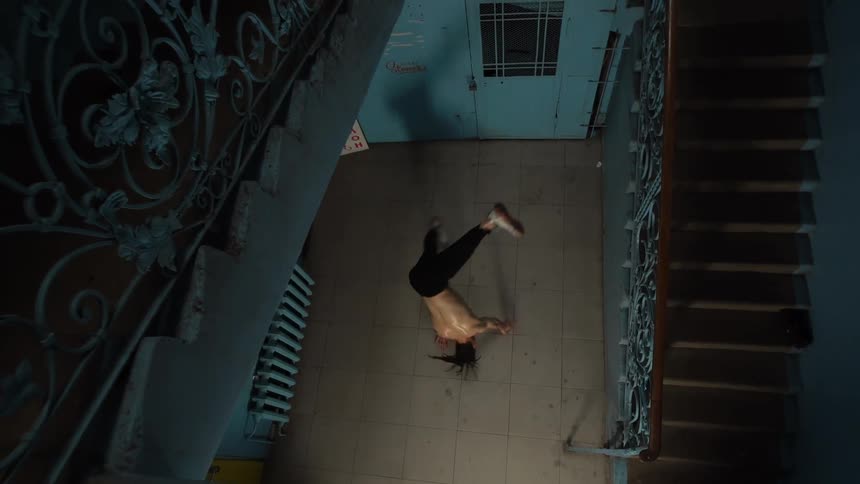 Man next to a staircase dancing break dance