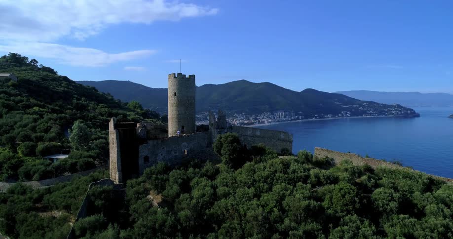 Aerial view of a castle on the peak of a seaside hill