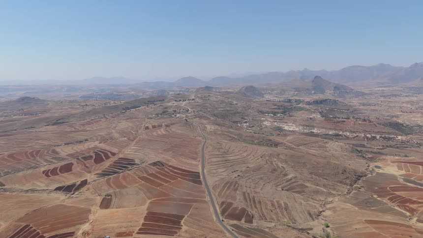 A road cuts through the desert away from a neighborhood