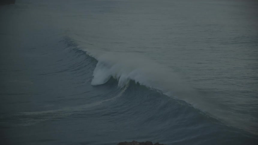 A big wave splashes and curls as it rolls into shore