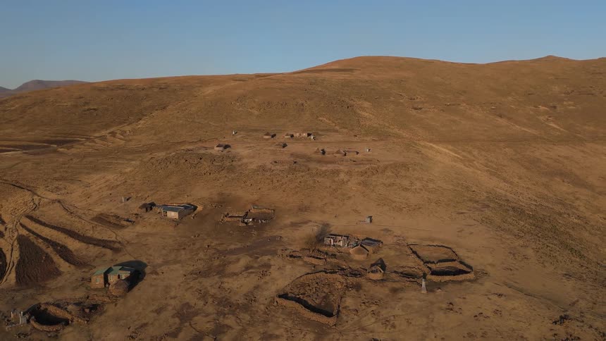 Vast undulating landscape with terraced fields and scattered clusters of structures