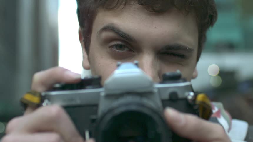 Men raising a camera to his eye preparing for a picture
