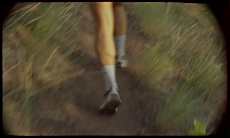 Feet of a person running on a trail