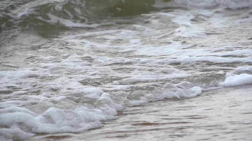 Medium-sized waves rolling into a beach
