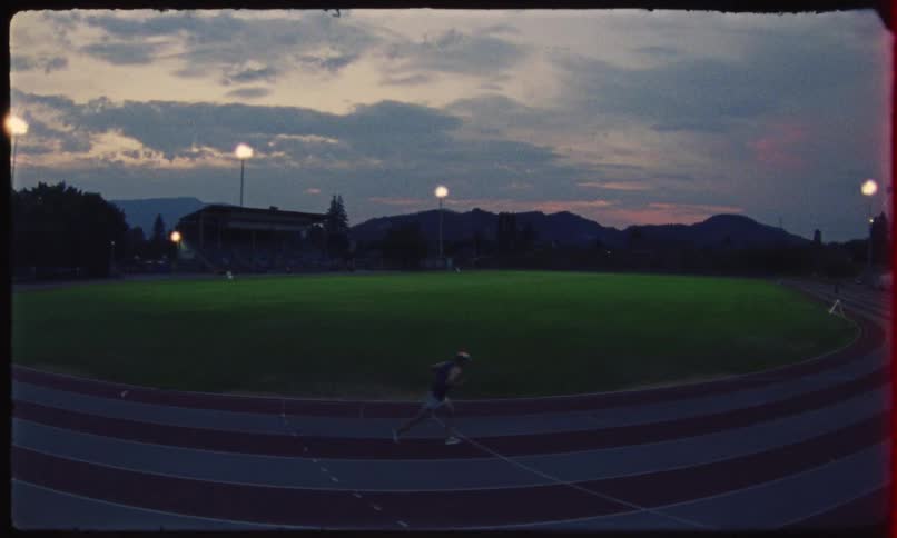 Man running on a running track on a cloudy day
