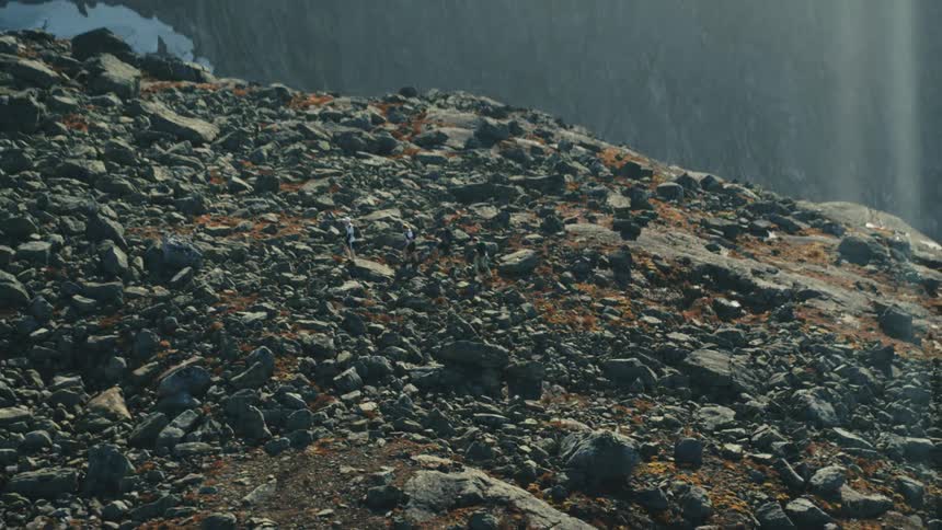 Four people hiking up a large rocky mountain