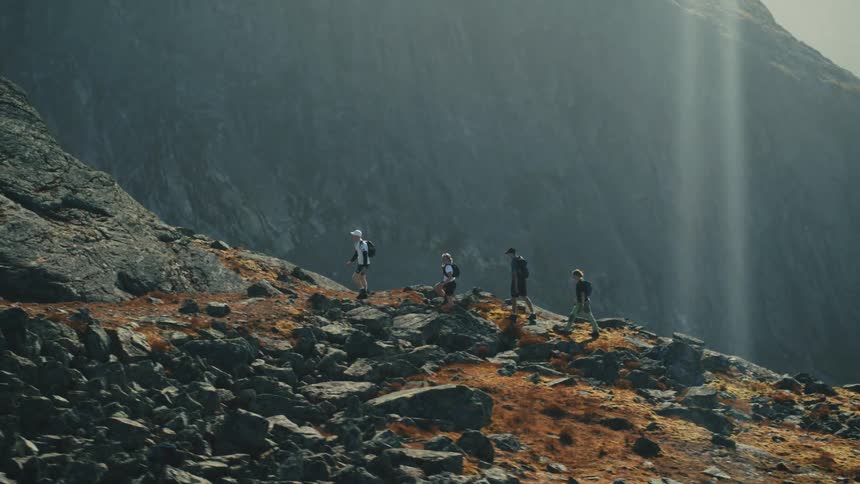 Four males hike along a path on the top of a mountain