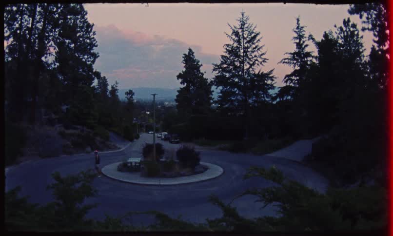 Person sitting on a bench at a roundabout gets up and starts walking