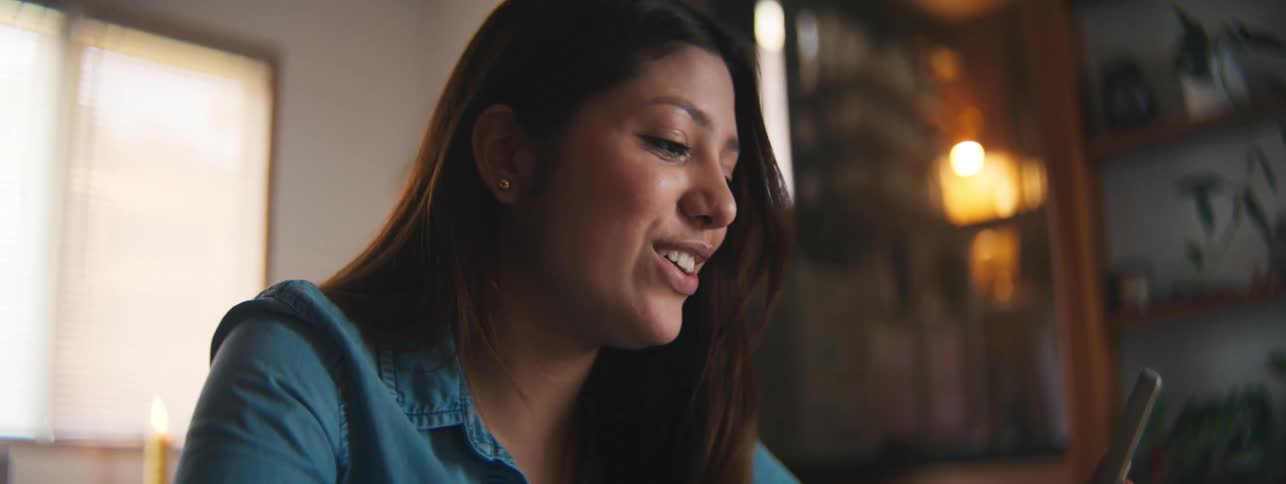 Smiling woman talking on video call while sitting at table