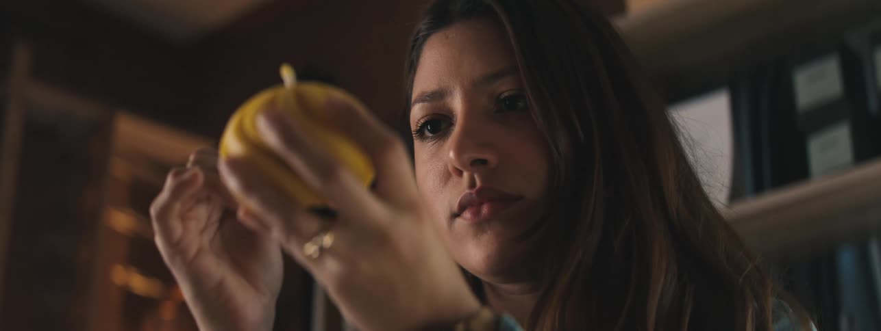 Woman working and carving a spherical yellow candle