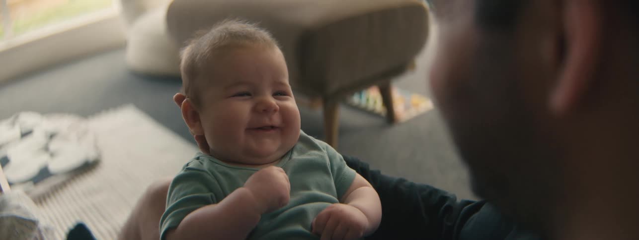 Man holding a baby in his hands and smiling