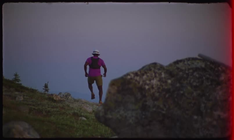 Man with white hat running on a mountain