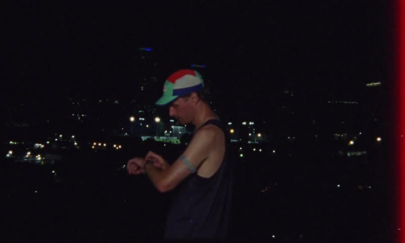 Runner looks at the city at night before continuing his run