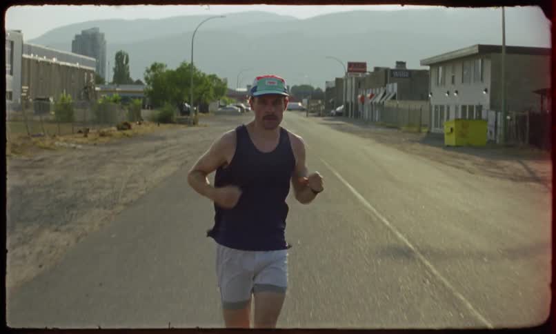 A jogger runs on a road leading out of a small rural town