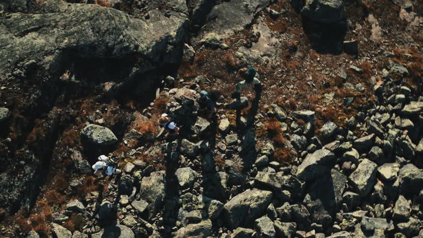 Hikers navigate a rocky mountainous terrain