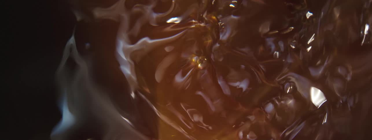 Extreme close up on a moving brown liquid