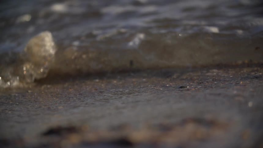 Closeup slow motion of waves running up on a beach
