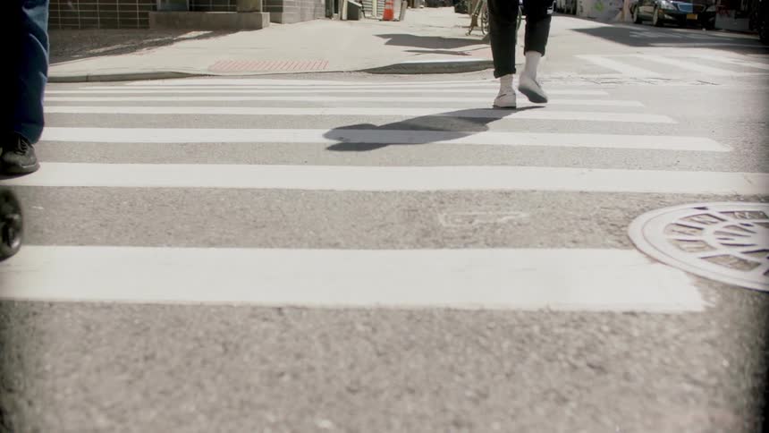 Pedestrians walk across the crosswalk at an urban intersection