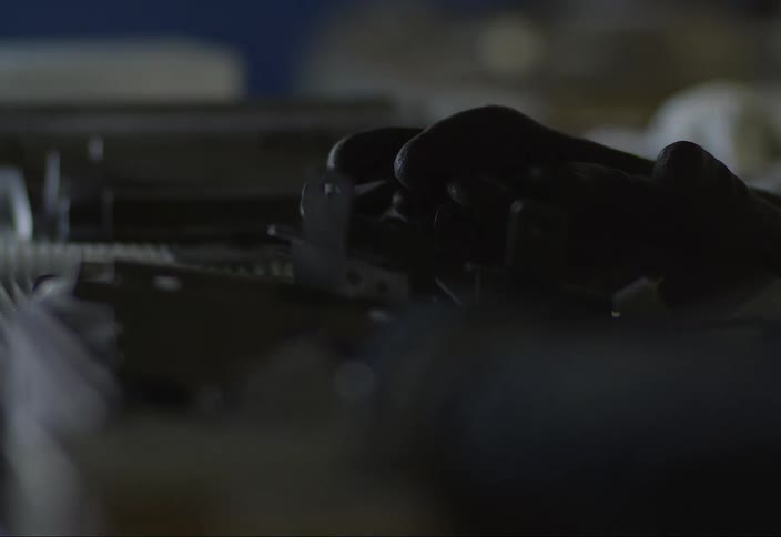Darkness falls on gloves lying on metal parts in a manufacturing facility