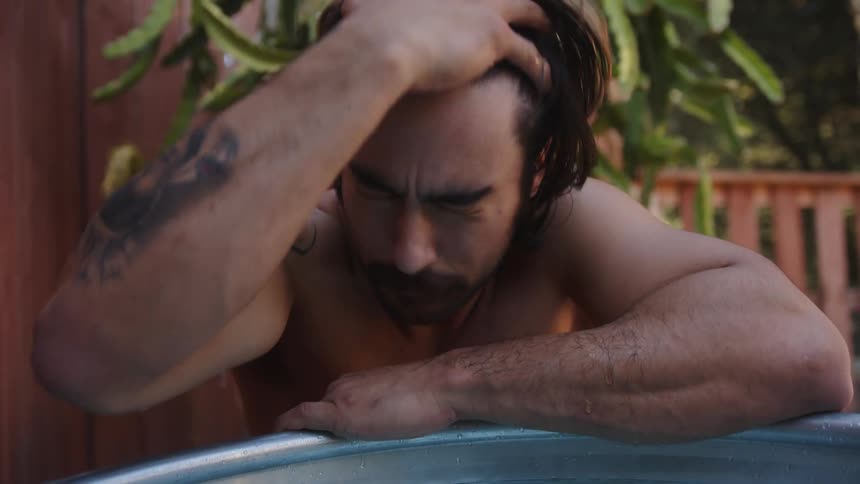 A sad man runs a wet hand through his hair
