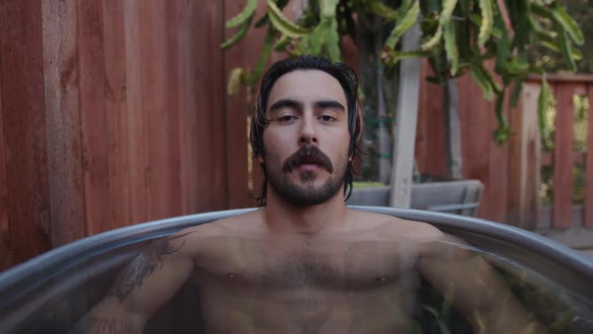 Man concentrating inside an outdoor bathtub
