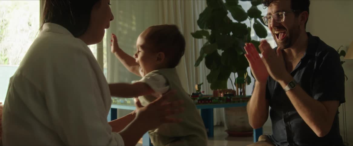 An image of a father and mother playing with their kid