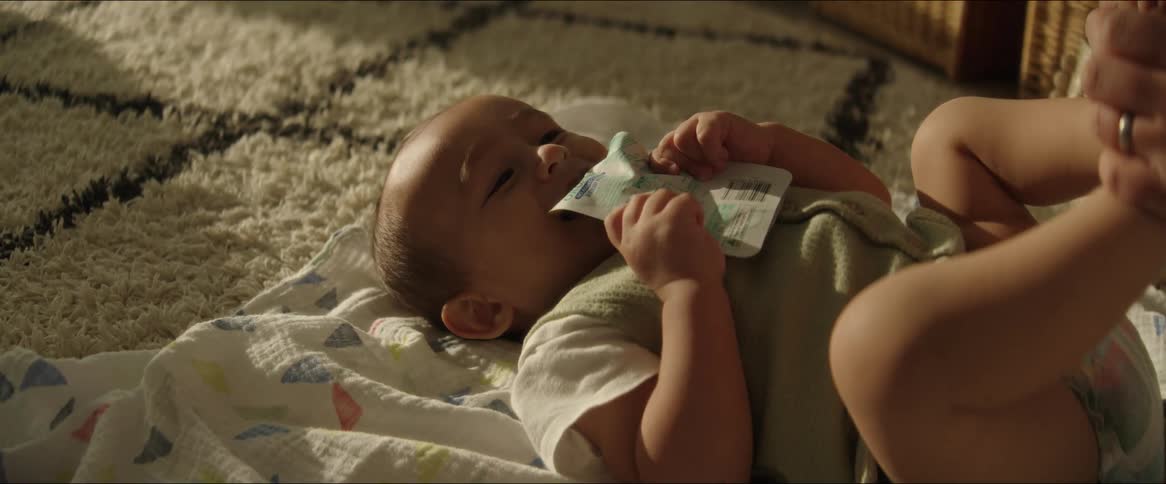 A baby laughs on the floor