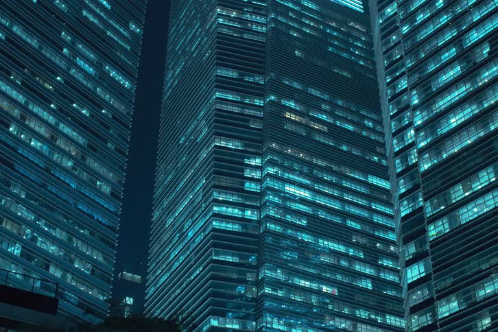 Lights of modern buildings flickering seen at night as the window lights come on