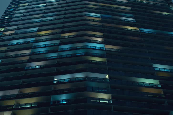 A night clip of a building filled with colorful lights turning on