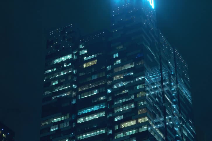 The window lights in the large building flash on night