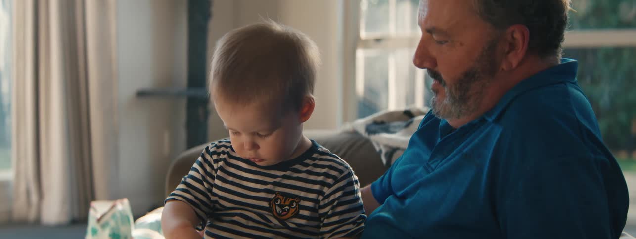Small child playing while sitting on fathers lap