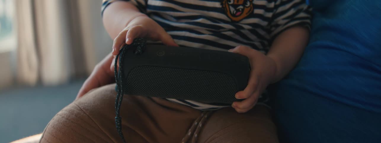 Childs hand interacting with a bluetooth speaker
