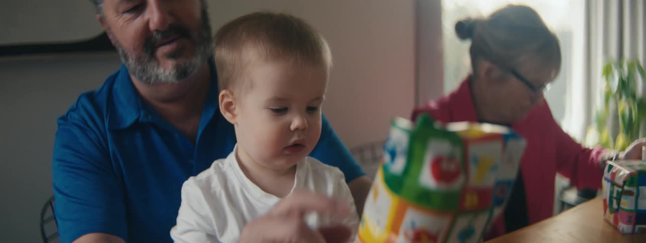 A father shows a baby a wrapped present