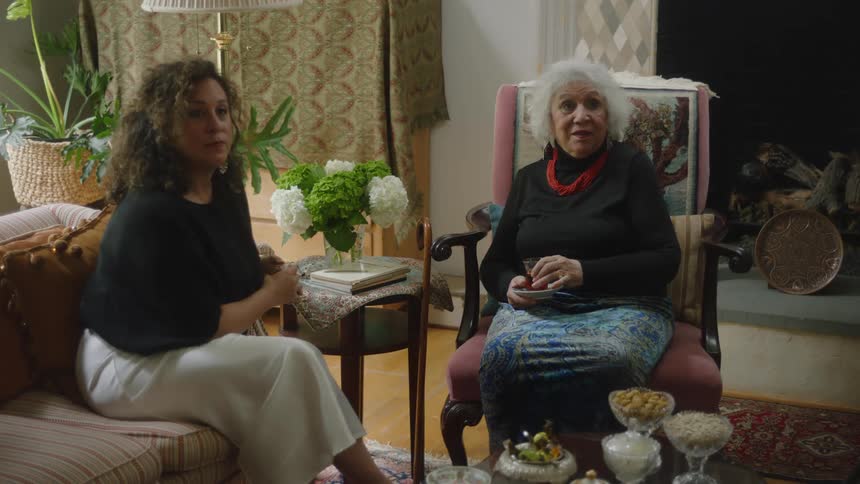 A couple women sit in a living room