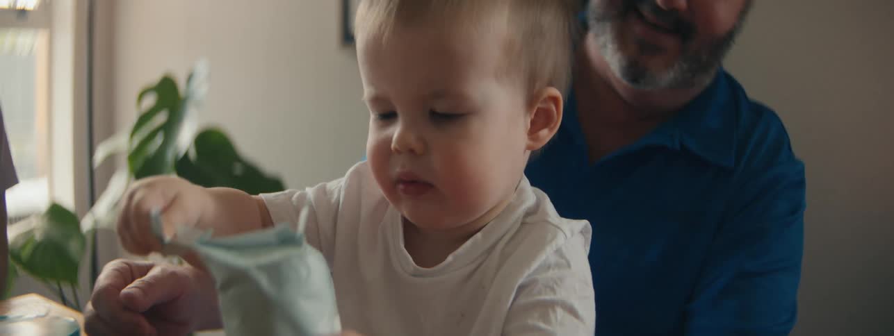Small child sitting opening a package