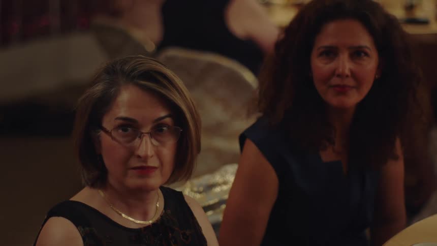 Two women looking in the same direction while sitting at a table