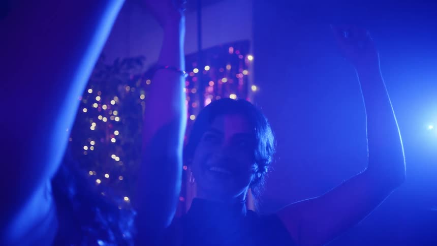 Two women dancing in a ballroom with lights