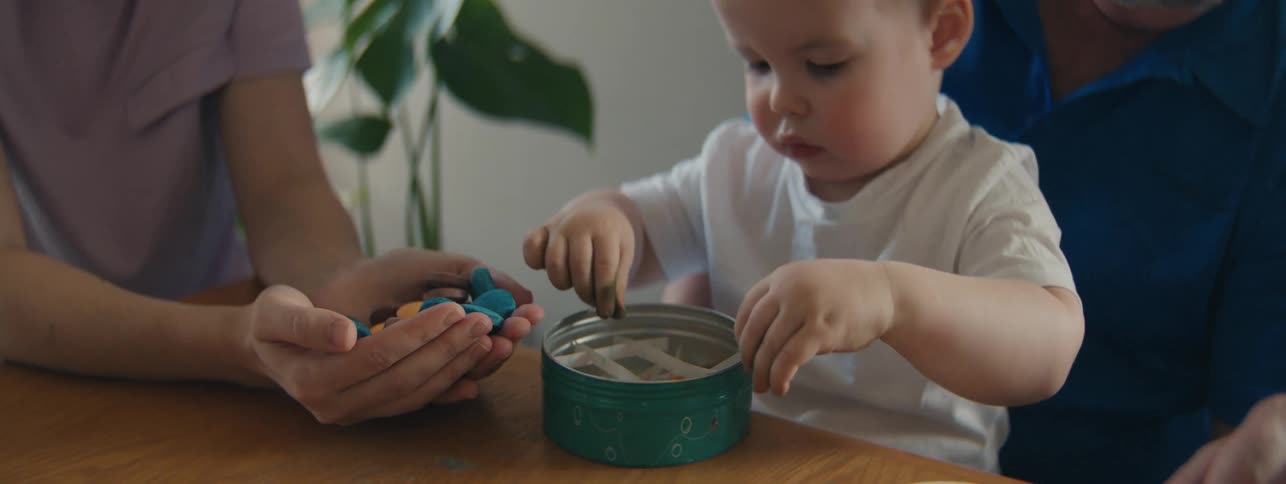 Little boy sitting on grandfathers lap playing with play dough