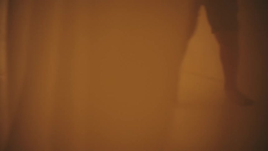 Legs of a child running between sheets in a room with flashing lights