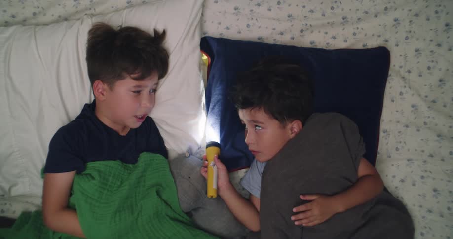 Two boys lying in bed hugging each other