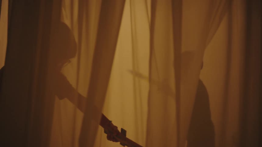 Two boys between curtains playing with swords