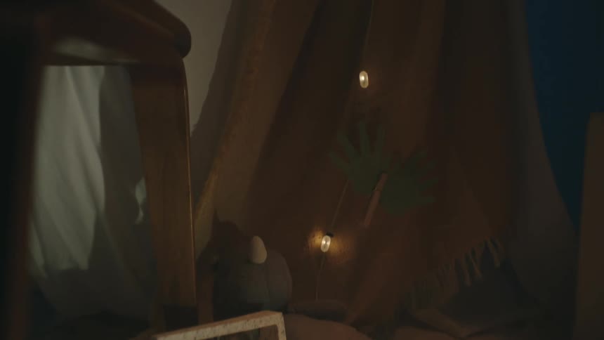 A door to a tent rustles in the wind next to a stuffed toy and a photograph of two boys