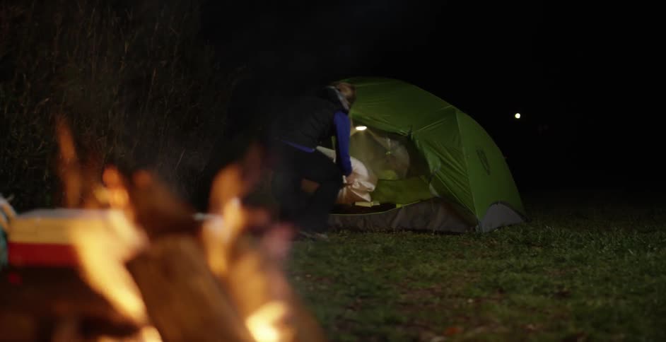 A camper places pillows into a tent
