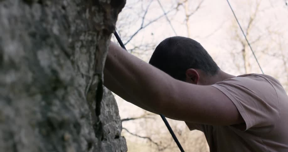 A rock climber holds onto a cliffside