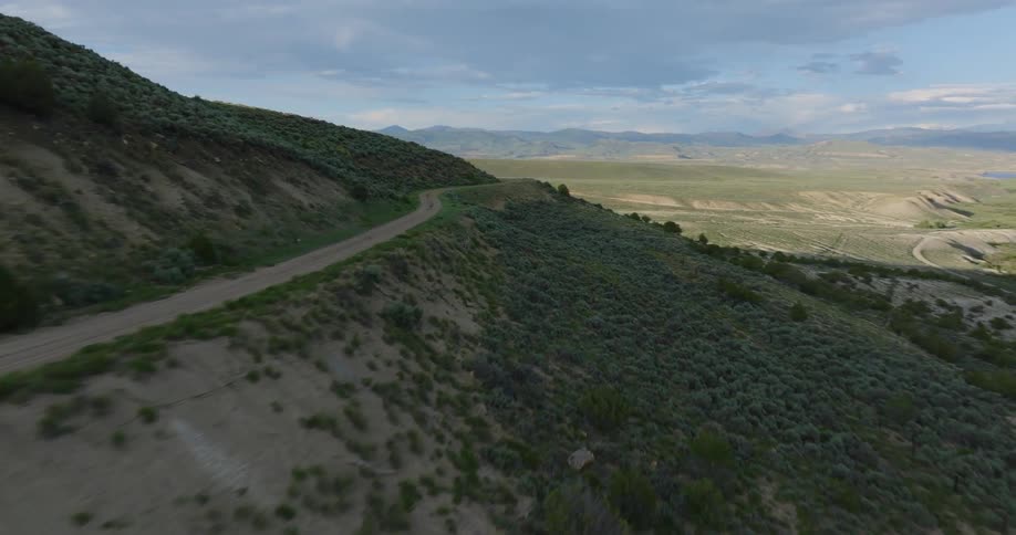 Roads cross hill slope and the nearby plains on a cloudy day