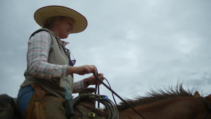 Woman with a happy expression sitting on top of a horse